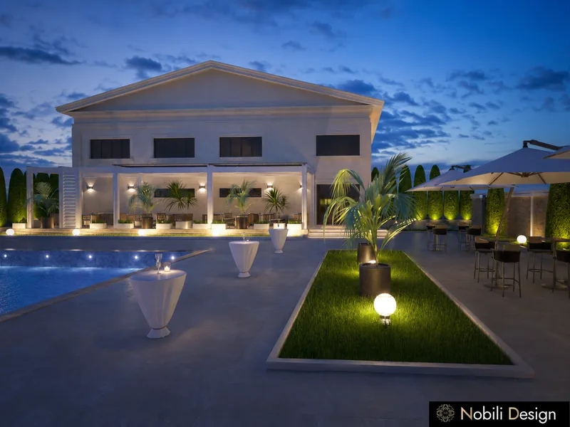 Event venue pool terrace with white cocktail tables and lit planters behind the banquet hall at dusk
